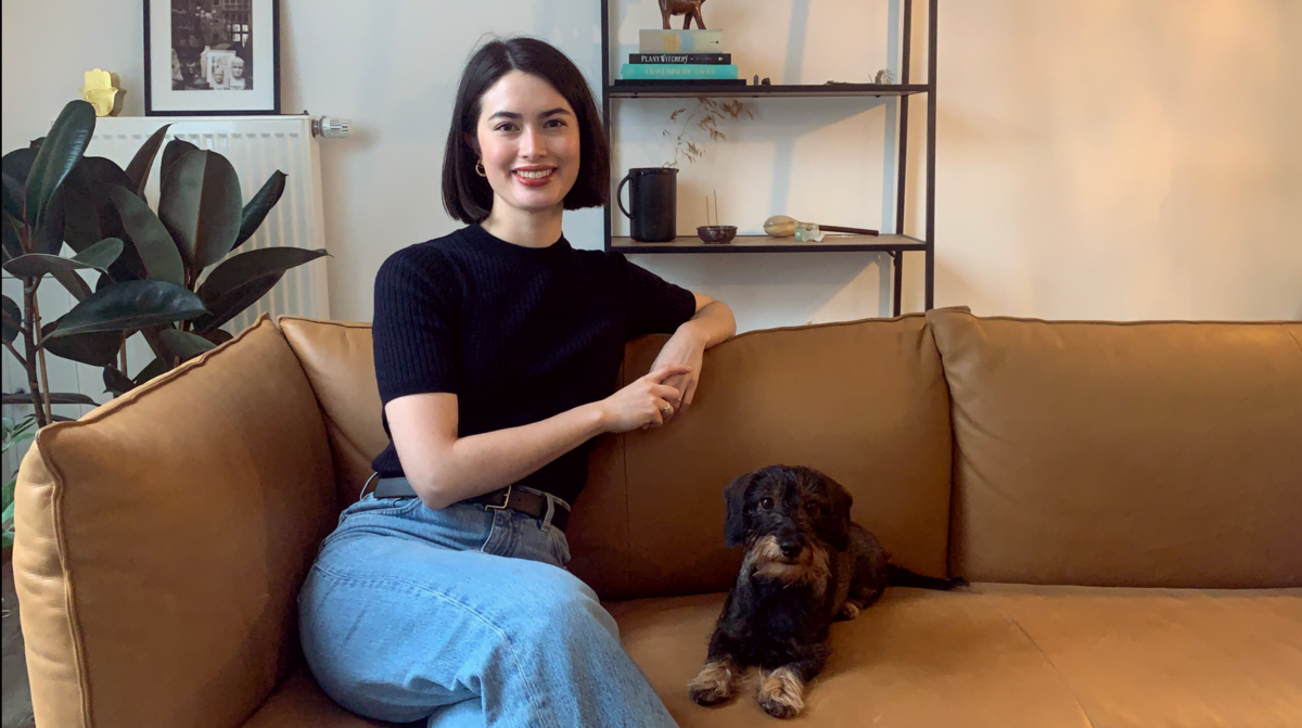 Communications Managerin Tatjana Schultze sitzt mit ihrem Hund auf dem Sofa
